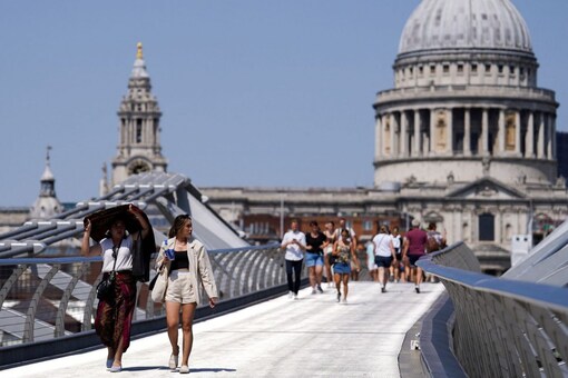 People cover themselves from the sun at Millennium Bridge during a heatwave, in London, Britain, July 18, 2022. Pic/Reuters