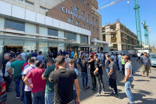 People queue to buy bread outside a bakery in Khaldeh, Lebanon July 28, 2022. REUTERS/Issam Abdallah