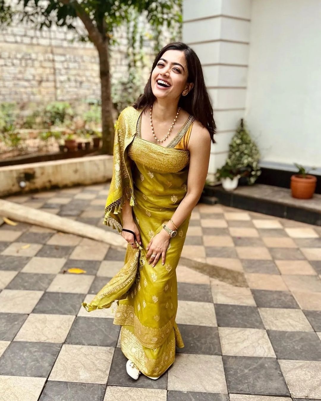 Rashmika Mandanna in Shanti Banaras’ olive green tussar georgette real zari saree paired with a hand-embroidered blouse, draped in traditional Coorg style.