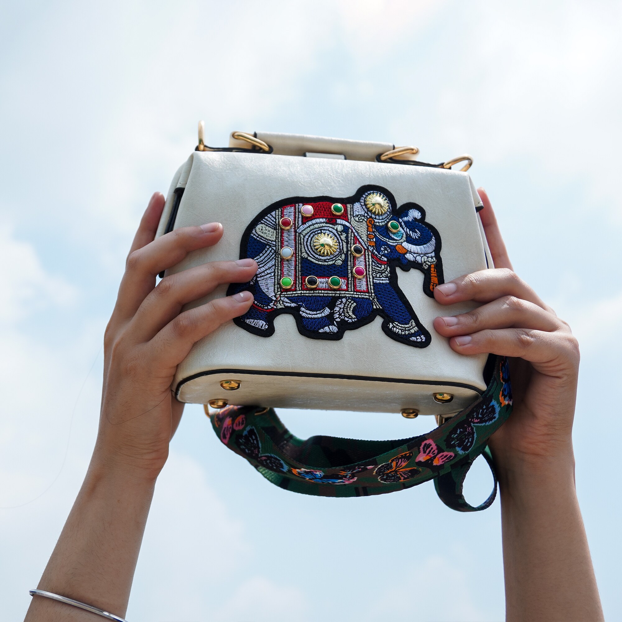 Pack your favourite accessories in a sling bag featuring an embroidered elephant