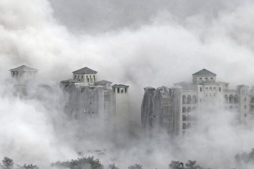 Residential buildings engulfed in dust after a controlled implosion demolished the 100-metre-high residential Twin Towers in Noida on Sunday. (Image: Sajjad HUSSAIN/AFP)