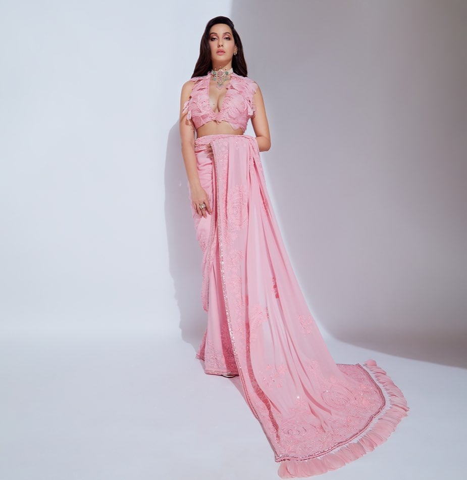 Nora Fatehi looks dreamy in a Manish Malhotra pink saree paired with a dainty blouse with feathers.