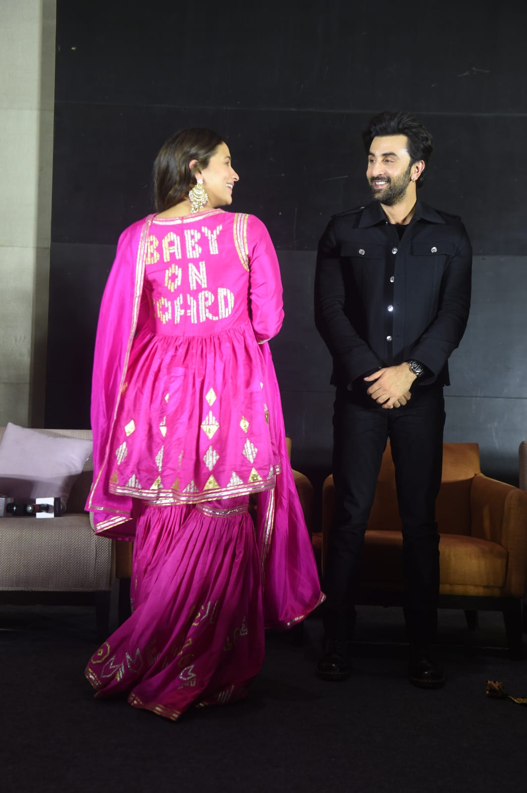 Alia Bhatt shows the 'baby on board' signage on her pink sharara as Ranbir Kapoor looks on. 