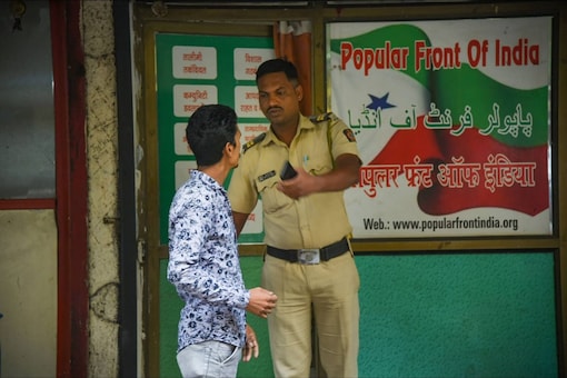 A security personnel keeps vigil outside the Popular Front of India (PFI) party office in Navi Mumbai on Thursday. A multi-agency operation was spearheaded by the National Investigation Agency (NIA) on the PFI in 11 states for allegedly supporting terror activities in the country. (PTI)