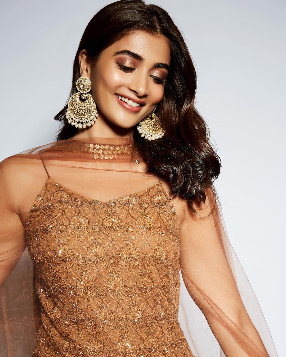Pooja Hegde dons a pair of chandbaali earrings with the outfit. 
