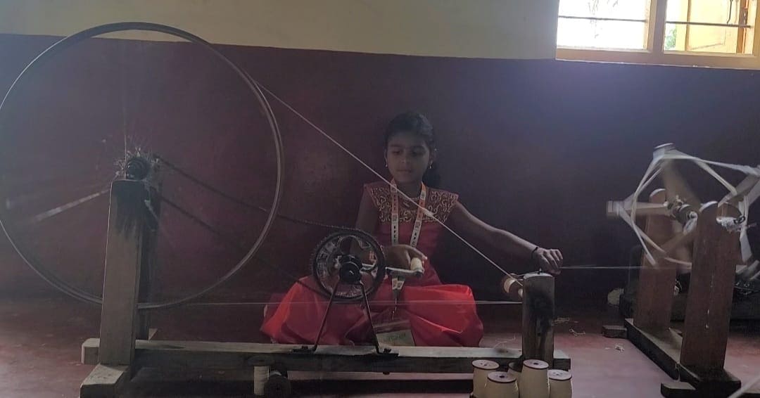 Harshita, the 9-year-old daughter of third generation weaver Shailja, tries her hand at spinning.  (News18)