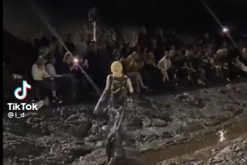 . In videos and photos from the show, one can see the mud covering the clothes and boots of the rapper as they walk past. (Credits: Twitter)