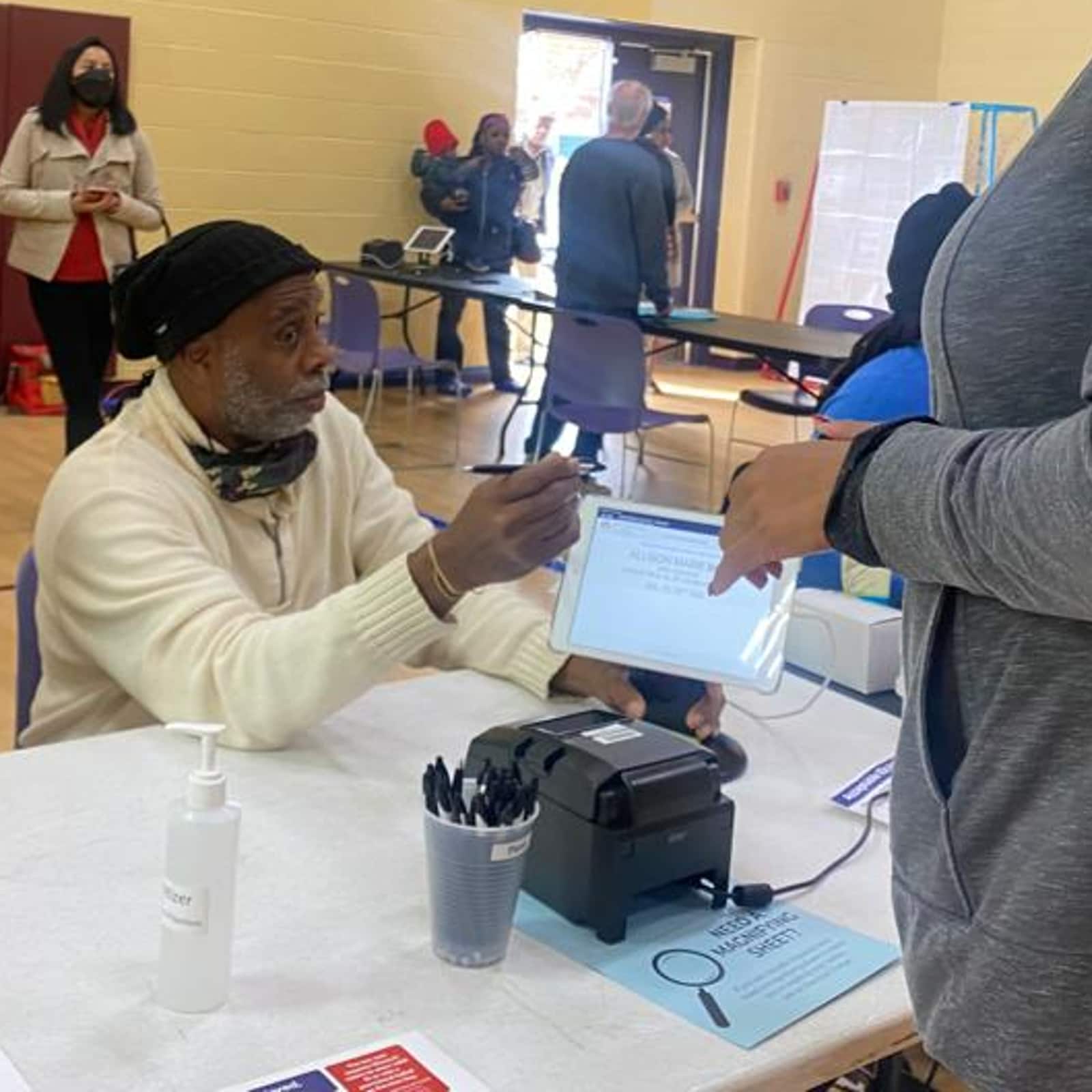 Um funcionário eleitoral verifica a identidade de um eleitor dentro da cabine de votação na Escola Primária Barack Obama (Foto: Kamalika Sengupta/News18)