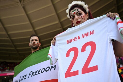 FIFA World Cup 2022: An Iranian fan holds a jersey in memory of Mahsa Amini, inside the stadium (Reuters)