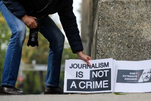 A photographer prepares to take pictures of signs placed next to a wall during a demonstration in solidarity with the Wikileaks founder Julian Assange. (AFP)