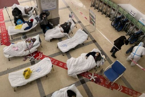 Covid-19 coronavirus patients lie on hospital beds in the lobby of the Chongqing No. 5 People's Hospital in China's southwestern city of Chongqing on December 23, 2022. (AFP)
