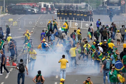 Protesters, supporters of former President Jair Bolsonaro, clash with police during a protest outside the Planalto Palace building in Brasilia, Brazil. (AP Photo/Eraldo Peres)