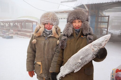 Fish vendors Marina Krivolutskaya and Marianna Ugai pose for a picture at an open-air market on a frosty day in Yakutsk, Russia, January 15, 2023. (Reuters)