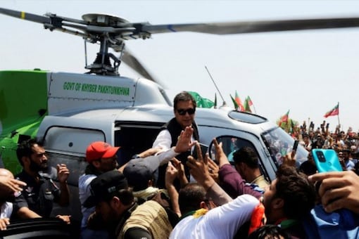Pakistan's ousted prime minister Imran Khan waves to suporters upon arriving on a helicopter to lead a protest rally in Swabai on May 25, 2022. (AFP)