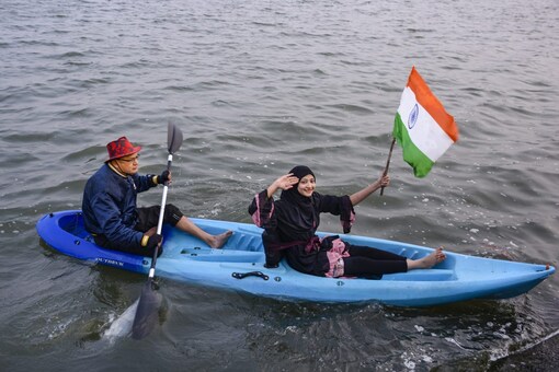 A swimmer holds a Tri-colour while riding a boat at River Tapi to celebrate the Republic day, in Surat, Thursday, Jan. 2023. (PTI Photo)  