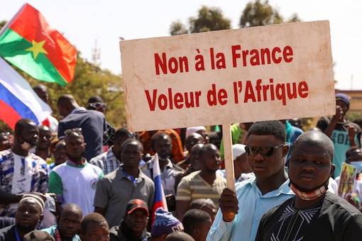 People hold a sign as they gather to show their support to Burkina Faso's new military leader Ibrahim Traore and demand the departure of the French ambassador at the Place de la Nation in Ouagadougou, Burkina Faso (Image: Reuters)