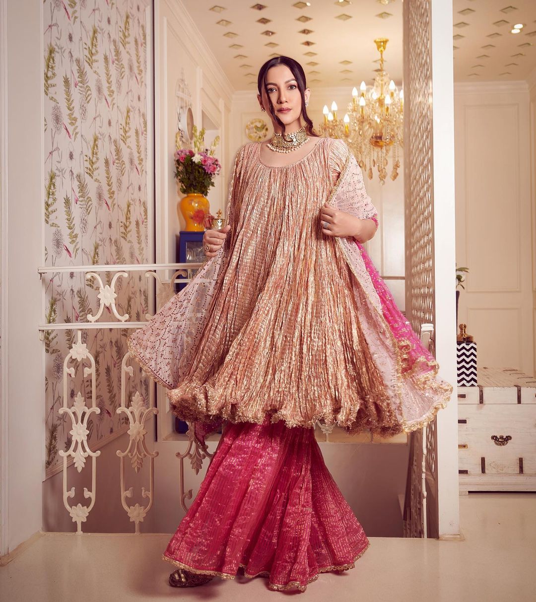 Gauahar Khan looks regal in a golden kurta and pink skirt. 