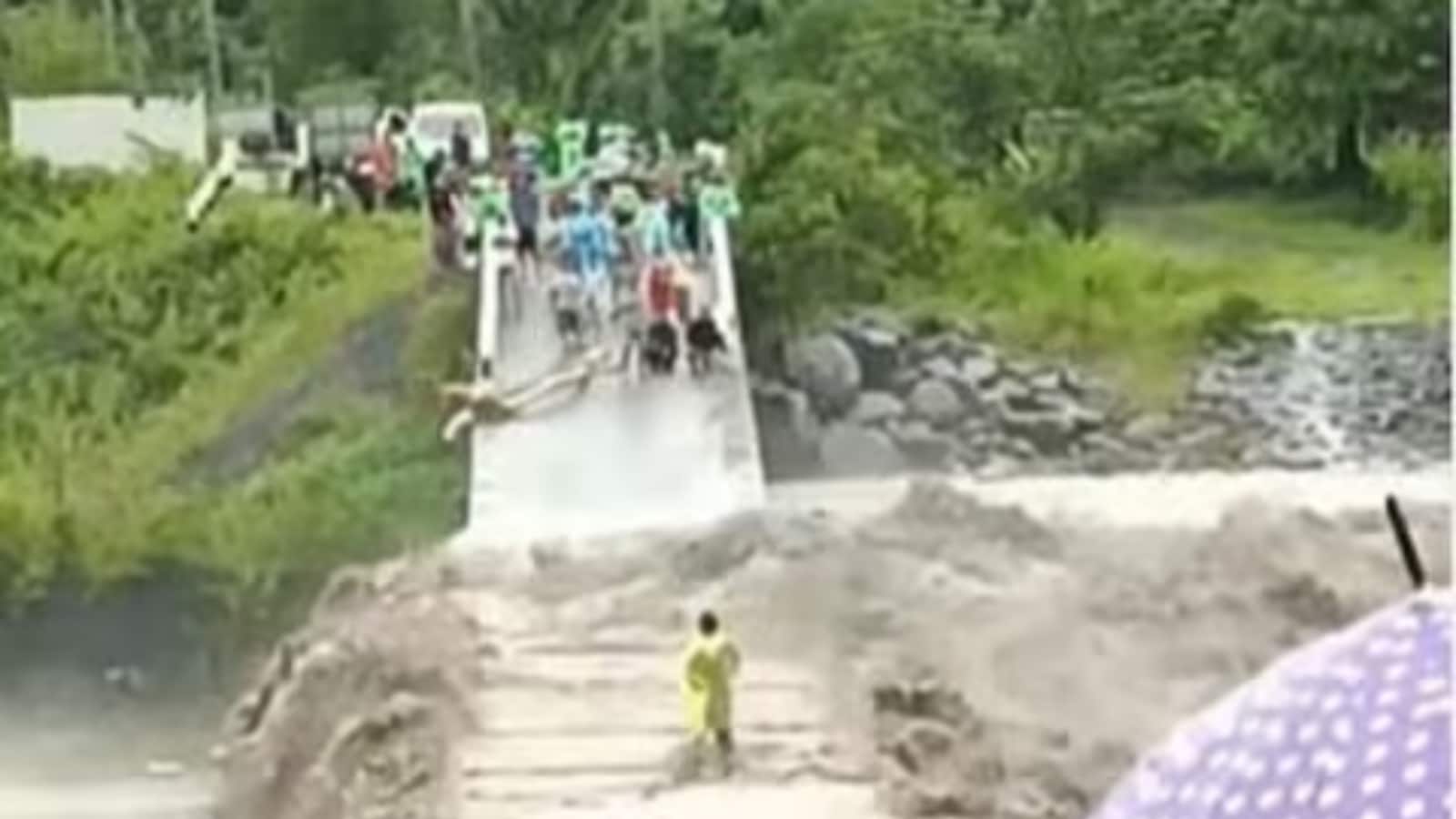 Seorang pria yang melintasi jembatan banjir di Indonesia mengejutkan penonton