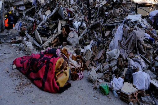 Destroyed buildings and bodies wrapped in blankets are seen following the deadly earthquake in Hatay, Turkey (Image: Reuters)