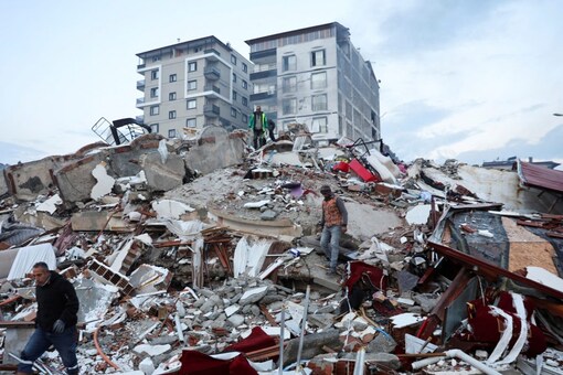 People walk amid rubble following an earthquake in Hatay, Turkey. (Image: Reuters)