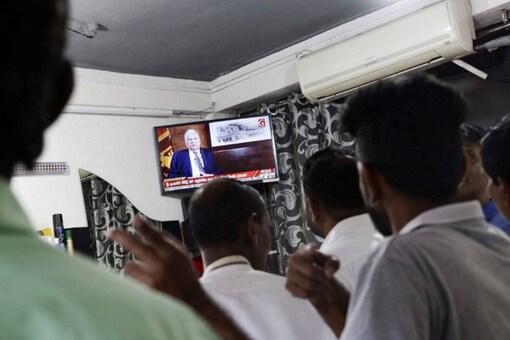 Supporters of President Ranil Wickremesinghe watch the TV while he addresses the nation, after the International Monetary Fund's executive board approved a $3 billion loan, in outskirts of Colombo, Sri Lanka (Image: Reuters)