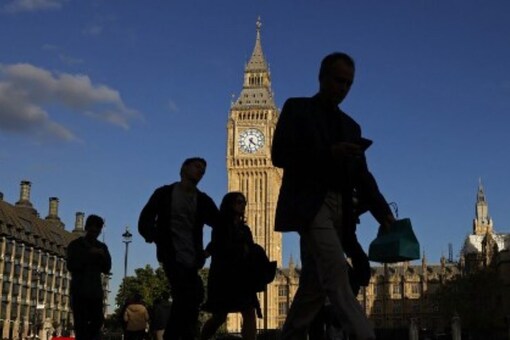 Pedestrians walk plast the Elizabeth Tower, more commonly known as Big Ben for the bell inside the tower's clock, at the the Houses of Parliament in central London on October 11, 2022. (AFP)