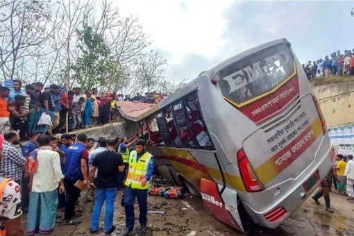 People gather after a bus met with an accident in Madaripur on March 19, 2023. (AFP)