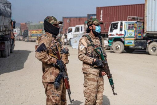 Armed Taliban security personnel stand guard at a cargo truck parking lot at the Afghanistan-Pakistan Torkham border post, in Nangarhar province. (AFP)