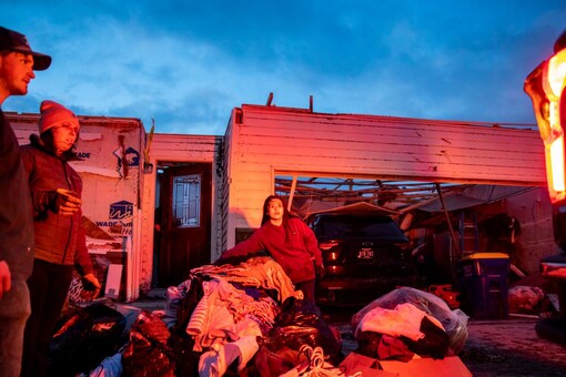 Community members load belongings into a pickup truck in front of a home in Hills, Iowa following a devastating tornado (Image: AP Photo/For Representative Purposes Only)