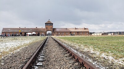 Woman Poses For Cheerful Photo at Former Nazi Concentration Camp