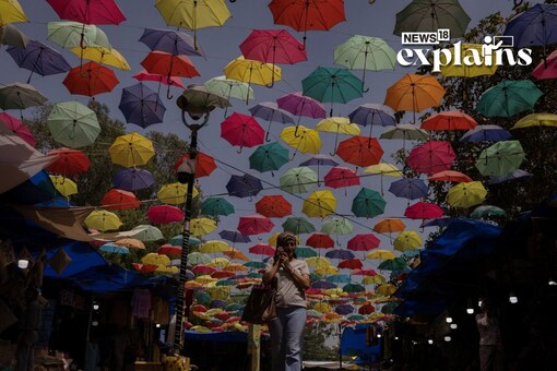 A woman speaks on a mobile phone as she walks through a market on a hot summer day in New Delhi, April 18, 2023. REUTERS/Adnan Abidi