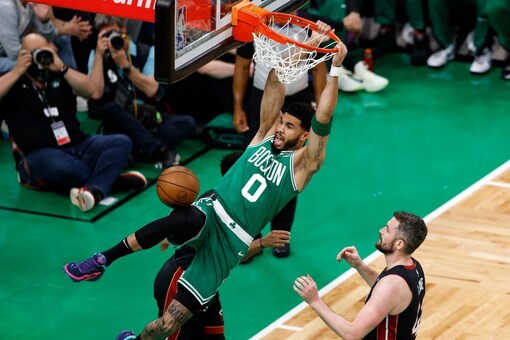 Boston Celtics forward Jayson Tatum, left, dunks as Miami Heat forward Kevin Love defends during the first half in Game 5 of an NBA basketball Eastern Conference Final series Thursday, May 25, 2023, in Boston. (AP Photo/Michael Dwyer)