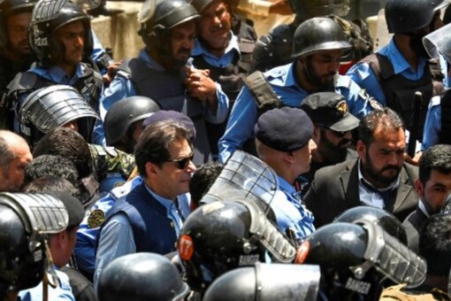 Policemen escort Pakistan's former Prime Minister Imran Khan (C) as he arrives at the high court in Islamabad (Image: AFP)