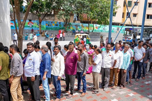 Karnataka Elections 2023: People wait in queues at a polling station to cast their votes in Bengaluru. (PTI)