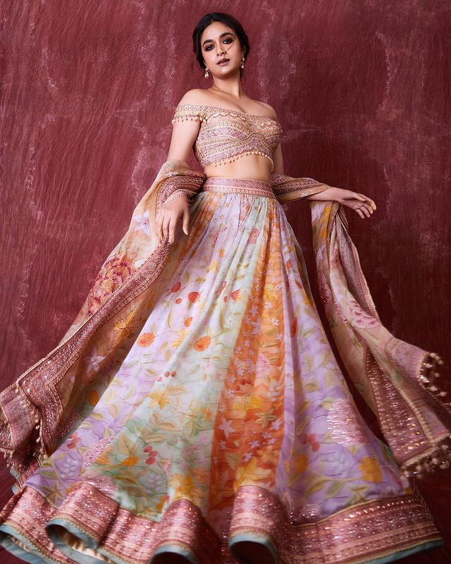 Keerthy Suresh looks resplendent in a colourful floral-printed lehenga. The off-shoulder choli gives it a modern twist.