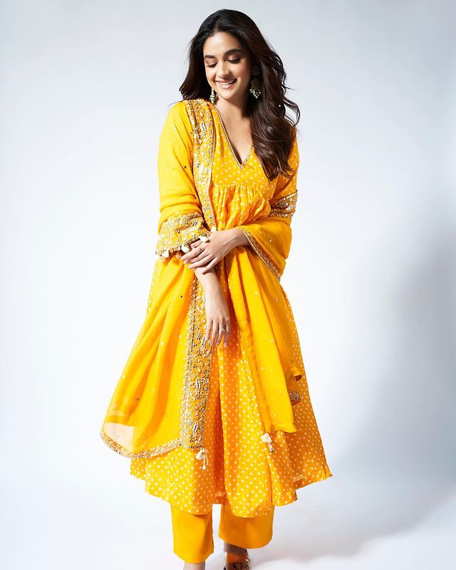 Keerthy Suresh exudes elegance in a vibrant yellow ethnic suit. The open hair adds to the beauty of the look. 