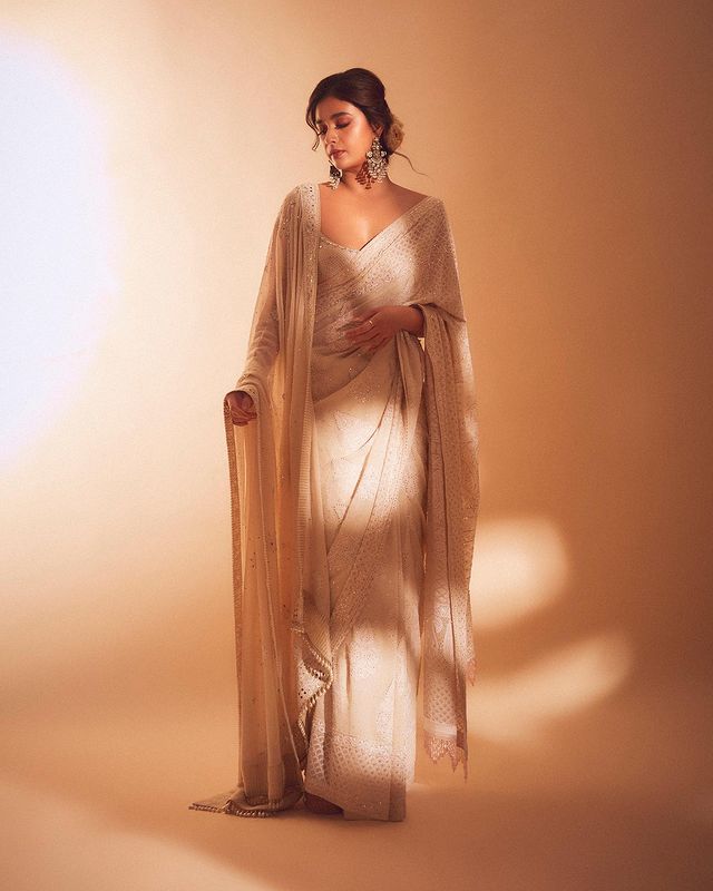 Keerthy Suresh looks gorgeous in a plain white saree. The massive earrings are the perfect touch to the subtle look.