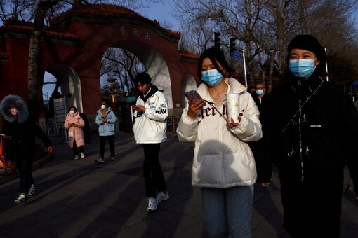 People, wearing masks to prevent coronavirus disease (COVID-19), walk along the street in Beijing, China. (Image: Reuters)