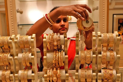 FILE PHOTO: A saleswoman shows gold bangles to a customer at a jewellery showroom on the occasion of Akshaya Tritiya, a major gold buying festival, in Kolkata, India, May 3, 2022. (Image: Reuters)