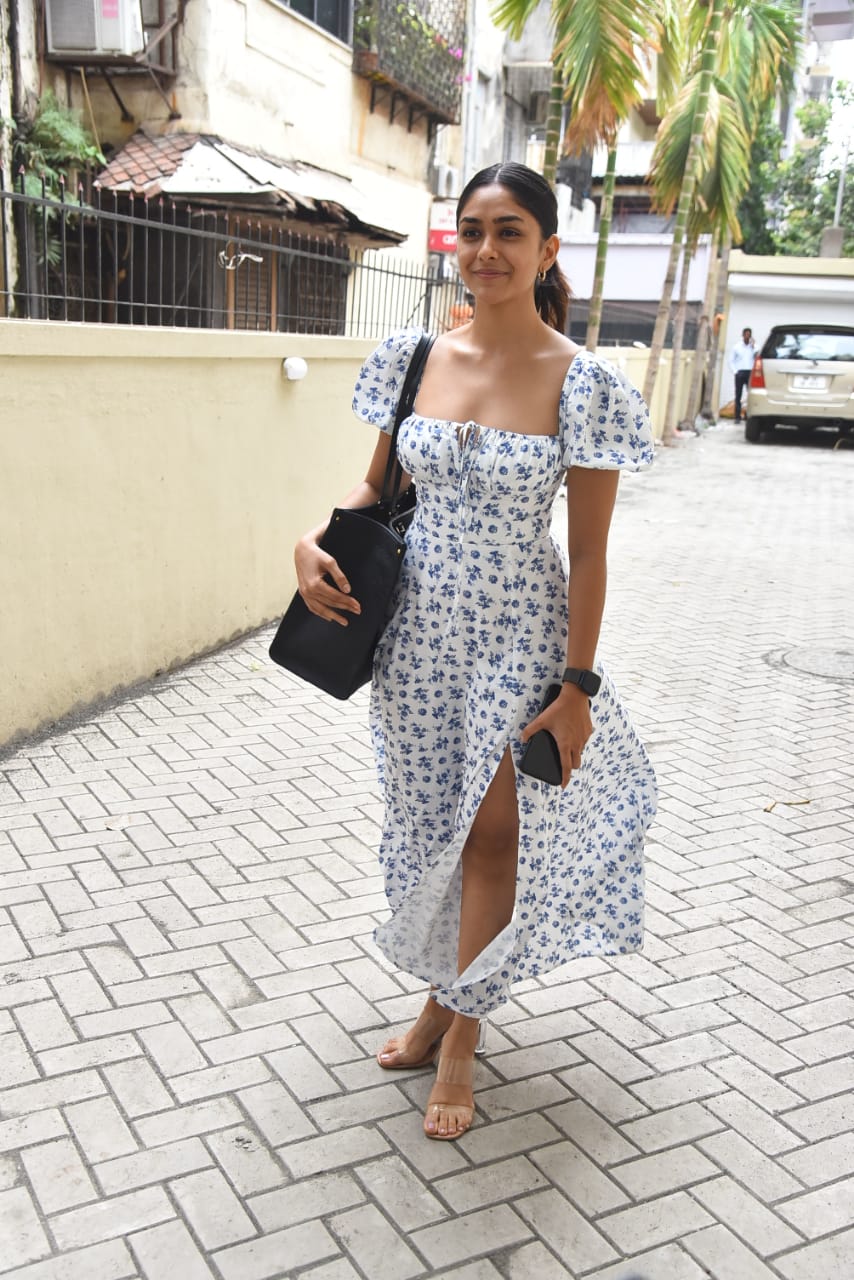  This easy-breezy white dress with floral motifs on it looked lovely on Mrunal. The thigh-high slit added the oomph factor to the look. (Image: Viral Bhayani)