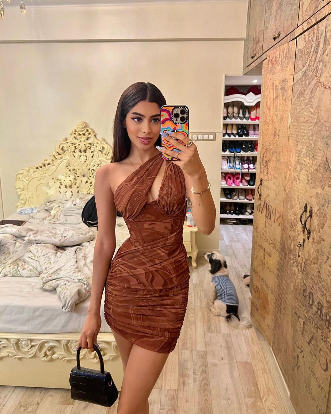  Khushi Kapoor is a bombshell in a brown marble-print micro mini dress. She accessorizes the look with a small black bag, golden bracelet and golden finger rings. (Image: Instagram) 