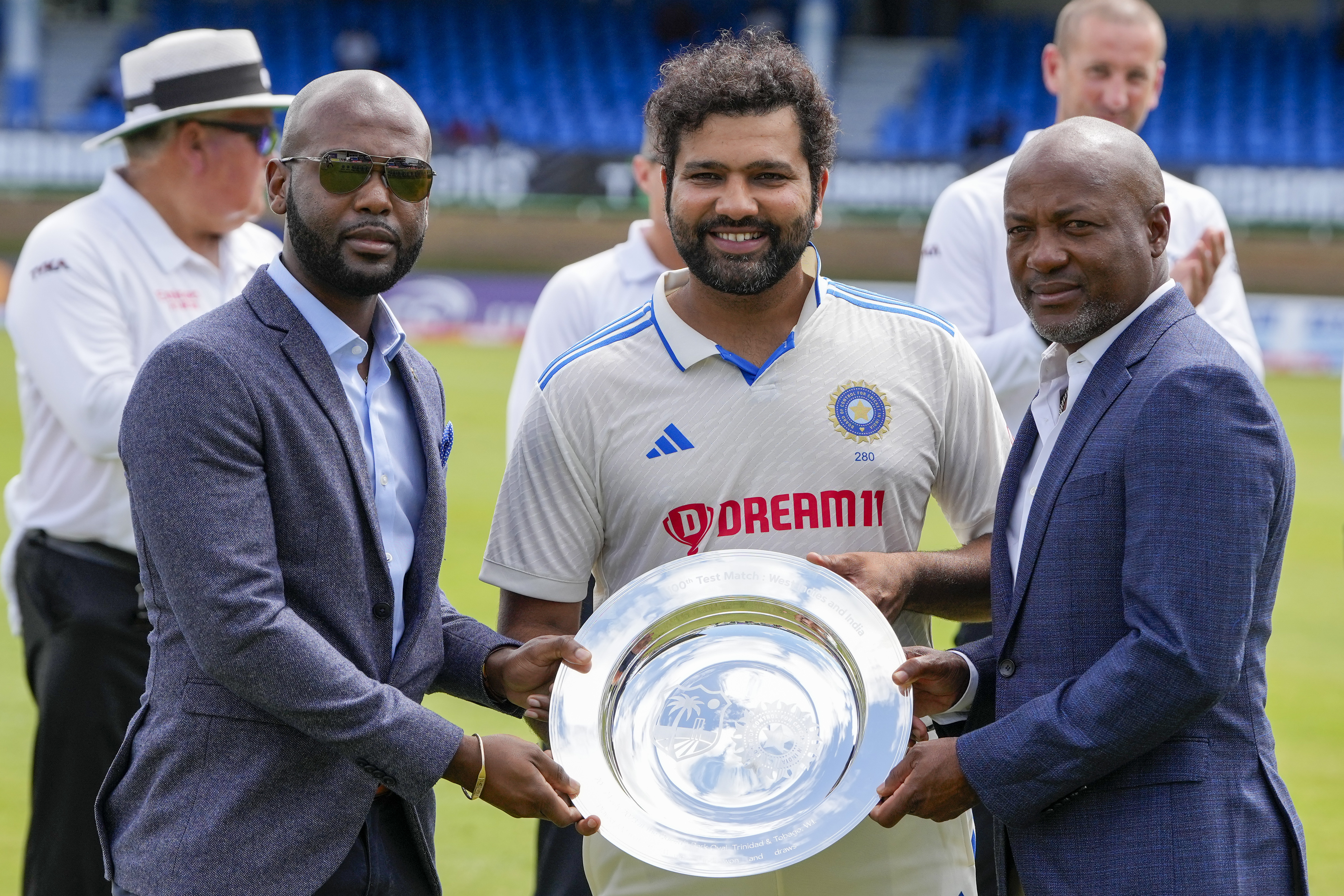 Indian captain Rohit Sharma and West Indies captain Kraigg Brathwaite were both awarded with mementoes by legendary cricketer Brian Lara to mark the 100th Test between India and West Indies (AP Photo). Indian captain Rohit Sharma and West Indies captain Kraigg Brathwaite were both awarded with mementos by legendary cricketer Brian Lara to mark the 100th Test between India and West Indies (AP Photo)