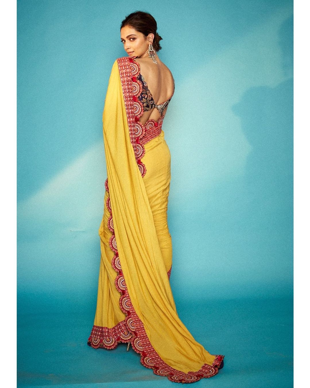  Deepika Padukone looks gorgeous in a red-bordered yellow saree, designed by Anamika Khanna, that she wore to her movie Chhapaak's promotions. The V-cut deep back blouse and statement earrings completed the look. (Image: Instagram)