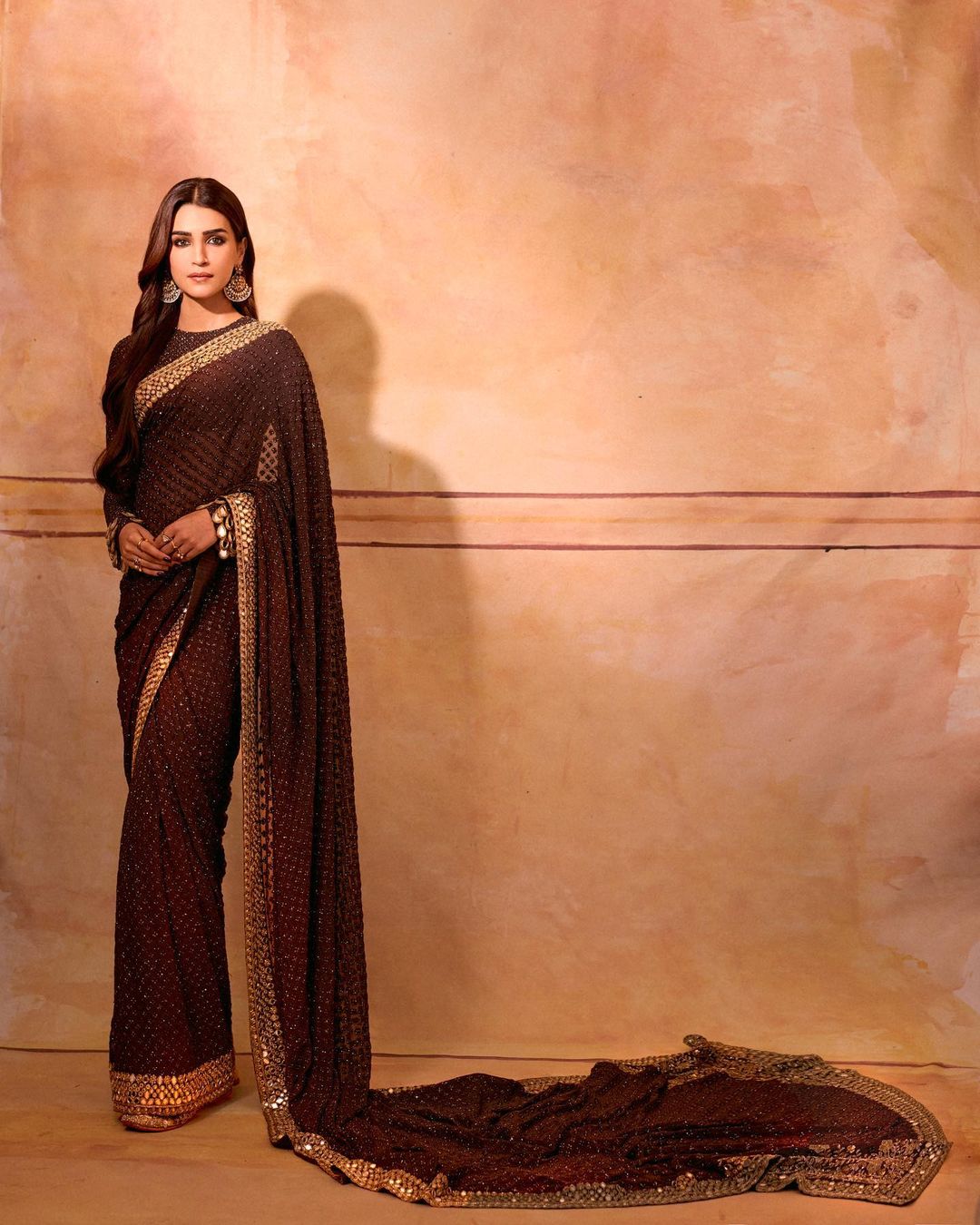 Weeks ago, Kriti Sanon set hearts ablaze in this six-yard wonder crafted by Arpita Mehta. The brown saree's allure was enhanced by delicate shimmers. The golden patti borders brought extra elegance to the drape. What added that extra punch of Indian charm? The full-sleeved blouse! But the showstopper was the jaw-dropping backless design, infusing a contemporary twist to this ethnic marvel. With Chandbalis as her sole accessories, Kriti let the saree take centre stage. Sporting middle-parted loose curls and minimal makeup, the actress’s ethereal appearance left us spellbound during the pre-release event of Adipurush. (Image: Instagram)