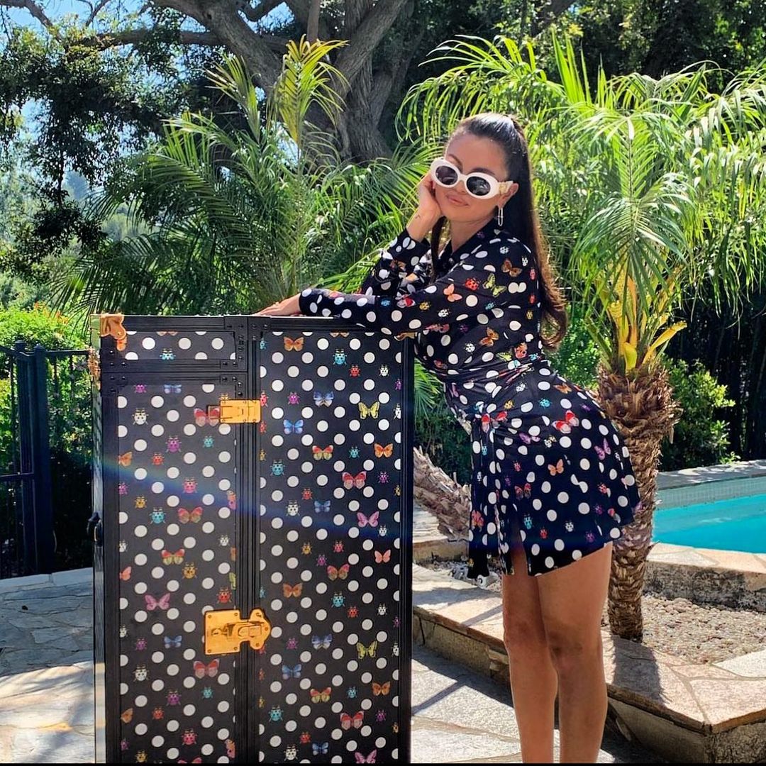 Selena Gomez looked stunning in a black wrap dress adorned with colourful polka dots. She paired her outfit with a stylish long ponytail and added a touch of vintage charm with white sunglasses. She captioned this picture as, “A little Versace/Dua moment.” (Image: Instagram) Selena Gomez looked stunning in a black wrap dress adorned with colourful polka dots. She paired her outfit with a stylish long ponytail and added a touch of vintage charm with white sunglasses. She captioned this picture as, “A little Versace/Dua moment.” (Image: Instagram)