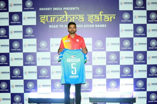 Abhishek holding up the official jersey for the Indian team for the Asian Games. (Credit: Twitter)