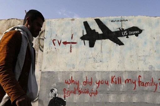 A man walks past a graffiti, denouncing strikes by US drones in Yemen, painted on a wall in Sanaa on 13 November, 2014. (Reuters File Photo)