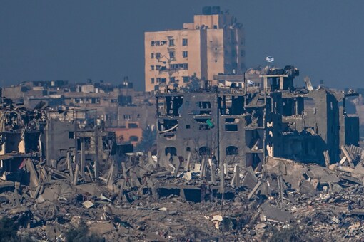 Israeli flags stand on the top of destroyed buildings in the Gaza Strip, as seen from southern Israel on November 18, 2023. (AP)