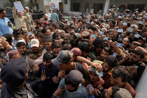 Police officers try to control immigrants, mostly Afghans, at a counter of Pakistan's National Database and Registration Authority, in Karachi on November 7, 2023. (AP)