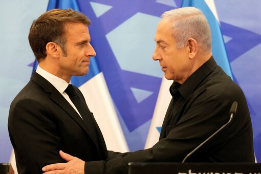 Israeli Prime Minister Benjamin Netanyahu and French President Emmanuel Macron embrace at a joint press conference, amid the Israeli-Hamas conflict, in Jerusalem, October 24. (Reuters) 